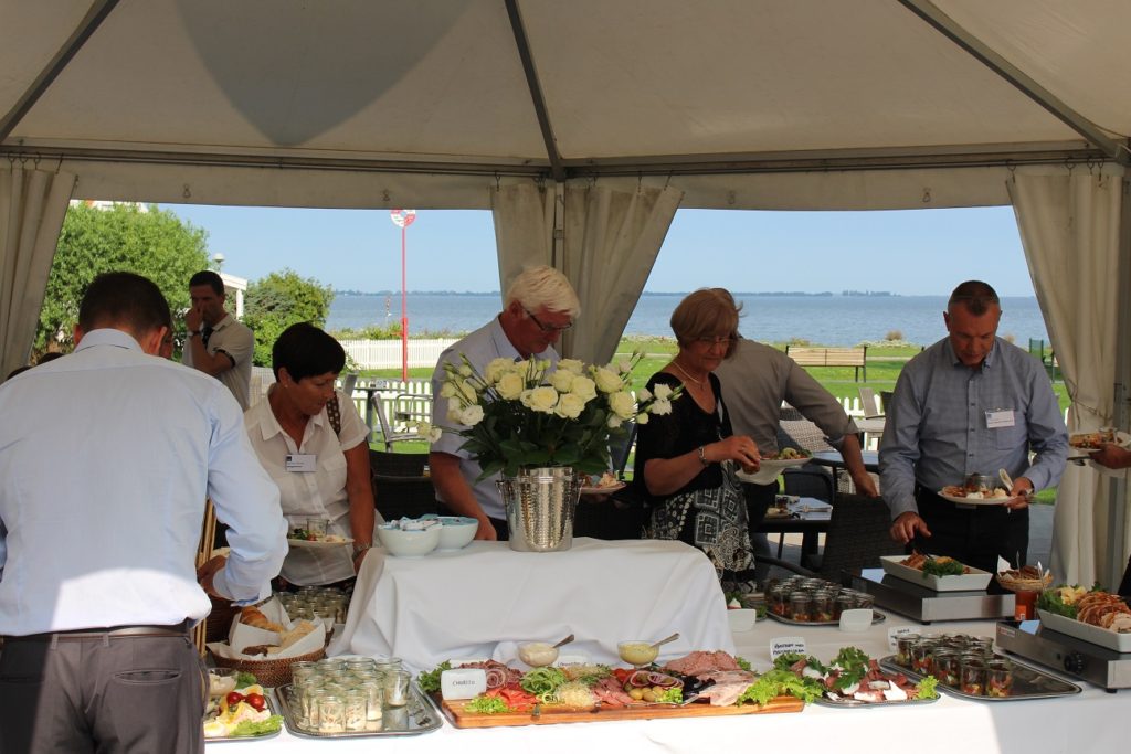 deltagerne-noed-en-fremragende-frokost-i-sommersolen-paa-bandholm-hotels-udendoersrestaurant-med-den-smukke-udsigt-til-havet